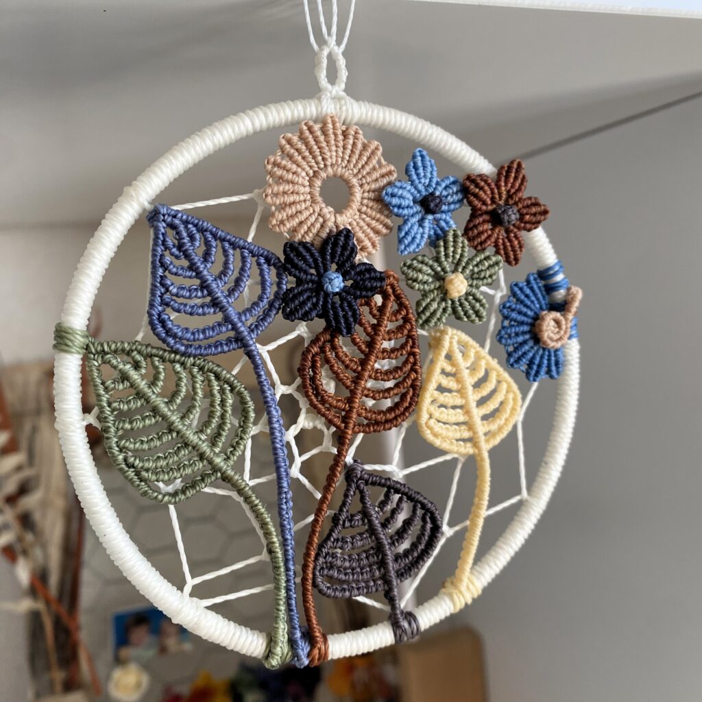 Entrelacs de fleurs et feuilles en micro-macramé pour un pendentif